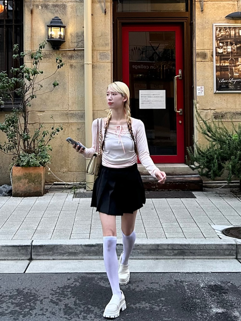 ピンク系のトップス、ブラック系のスカート、ホワイト系のローファーを着用したレディースの秋コーディネートの2枚目の写真