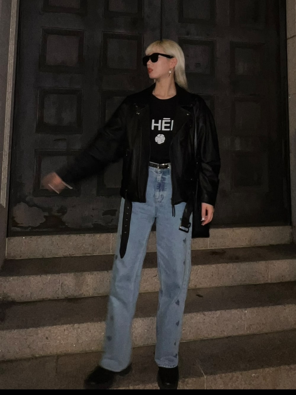 ブルー系のデニムパンツ、ブラック系のブーツ、ブラック系のTシャツ/カットソーを着用したレディースの春コーディネートの2枚目の写真