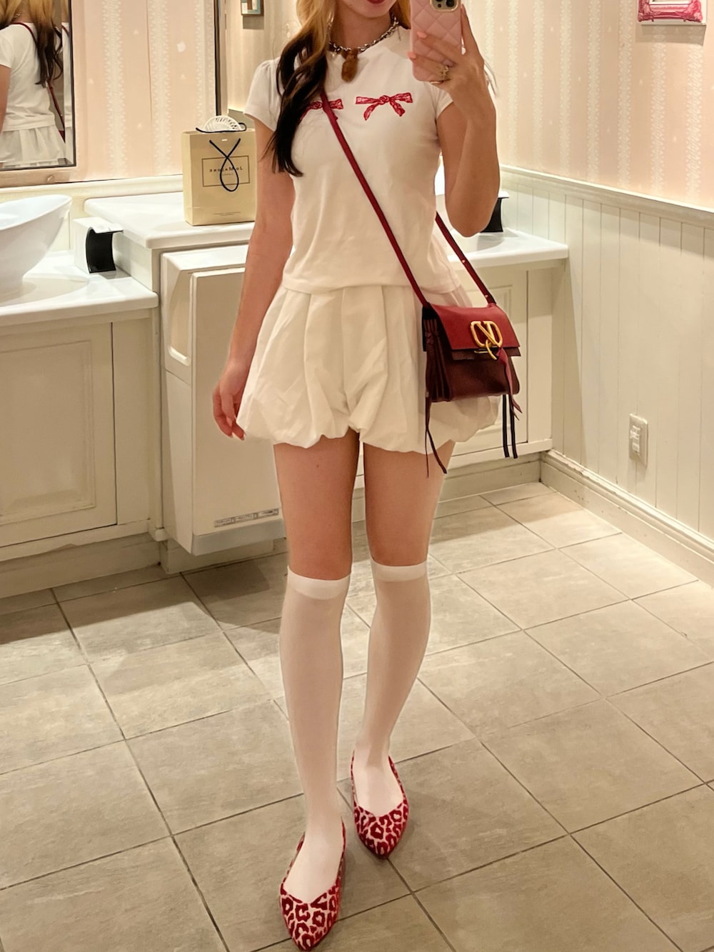 ホワイト系のTシャツ/カットソー、レッド系のショルダーバッグ、レッド系のバレエシューズを着用したレディースの春コーディネートの2枚目の写真