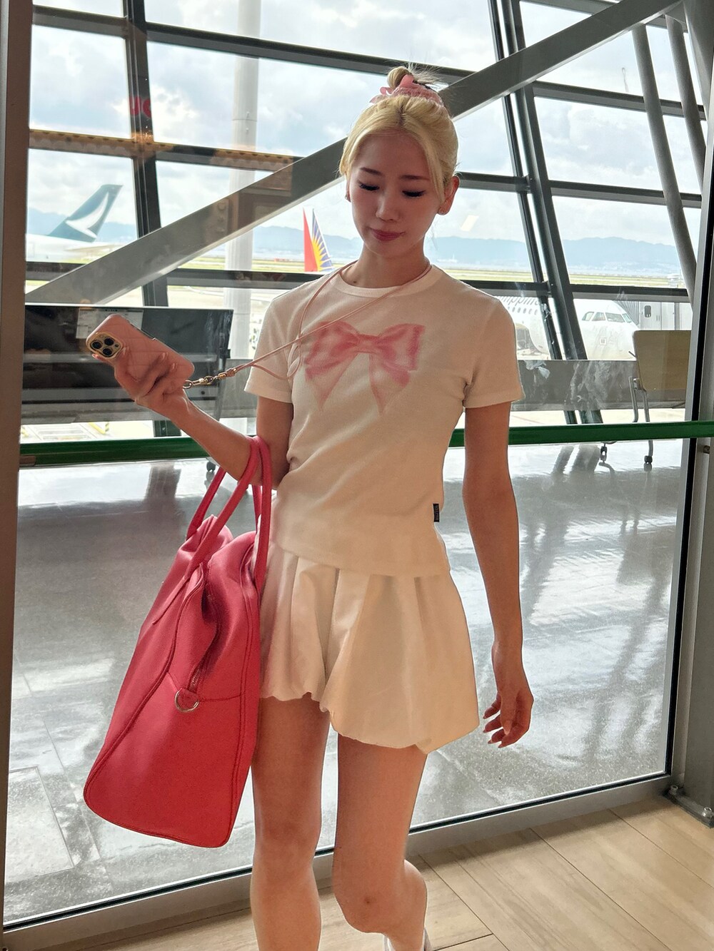 ピンク系のボストンバッグ、ホワイト系のTシャツ/カットソーを着用したレディースの春コーディネートの2枚目の写真