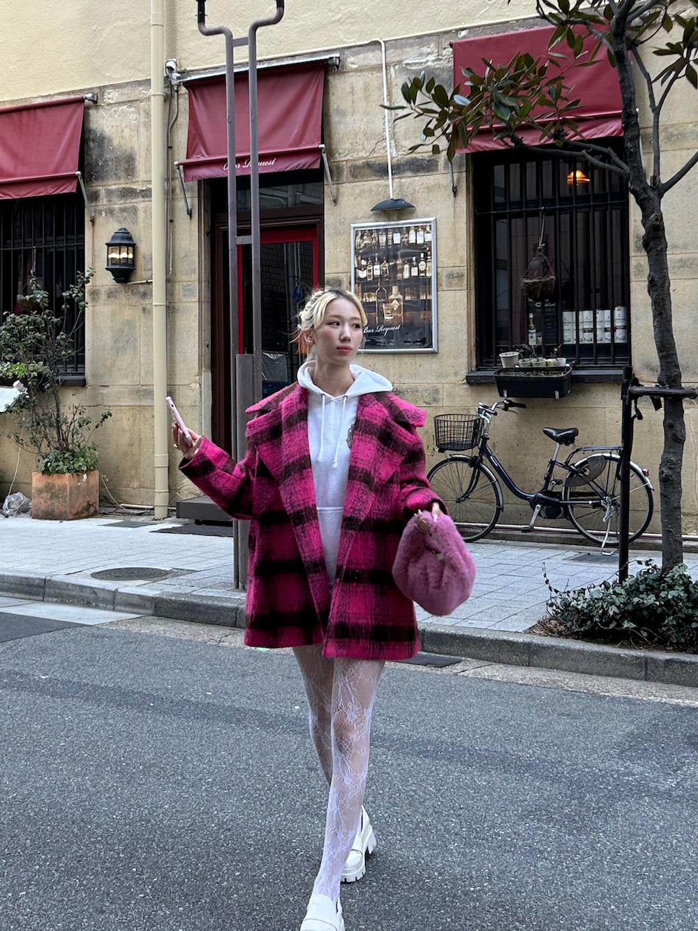 ピンク系のピーコート、ピンク系のハンドバッグ、ホワイト系のローファーを着用したレディースの春コーディネートの2枚目の写真