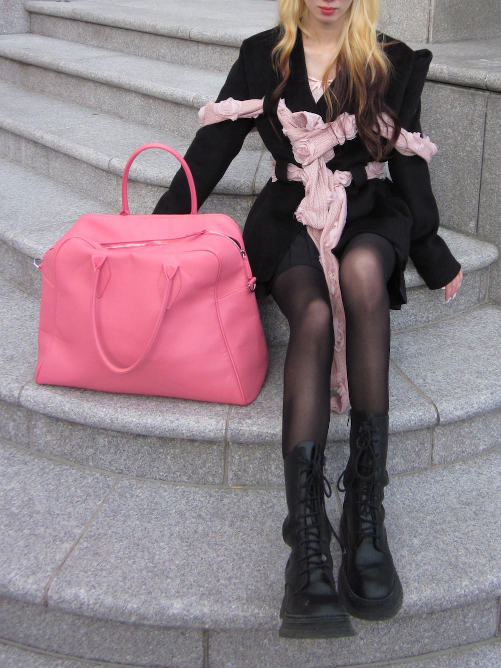 ピンク系のボストンバッグ、ブラック系のブーツ、ブラック系のジャケット/アウターを着用したレディースの秋コーディネートの3枚目の写真