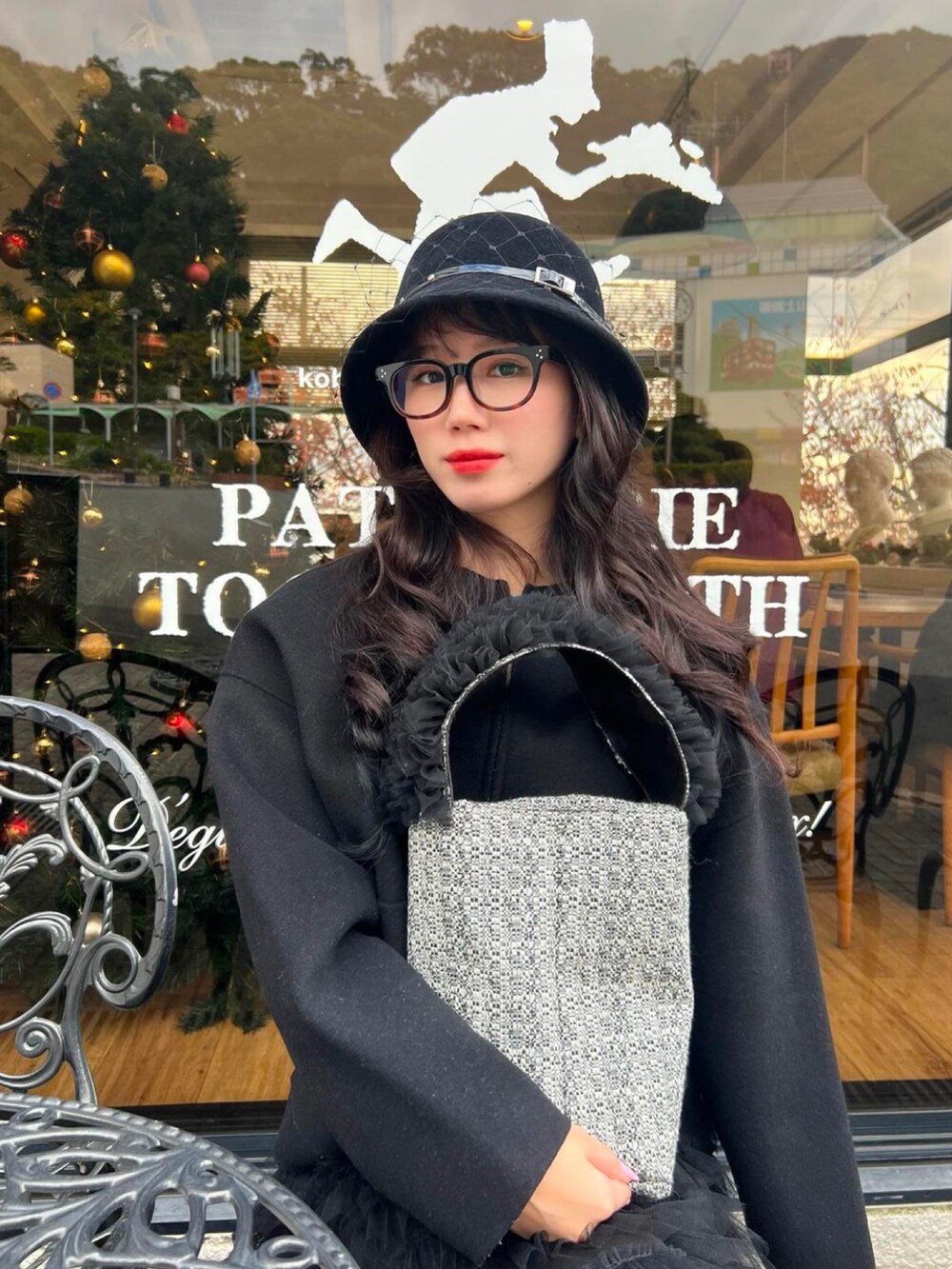 ブラック系のスカート、ブラック系のバッグ、ブラック系の帽子を着用したレディースの冬コーディネートの2枚目の写真