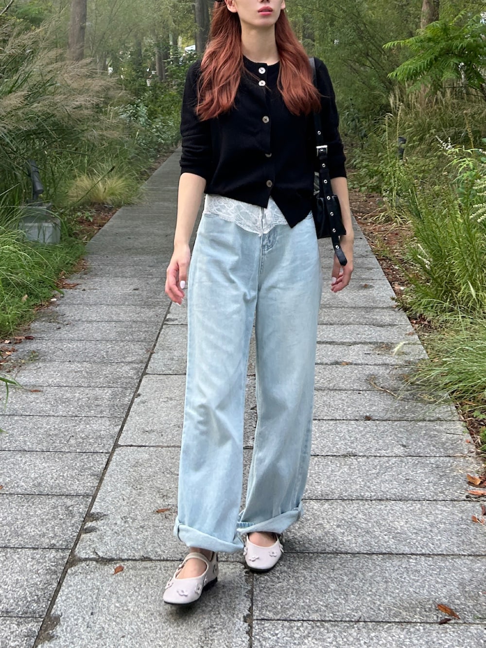 ブラック系のカーディガン/ボレロ、ブルー系のデニムパンツ、ピンク系のバレエシューズを着用したレディースの秋コーディネートの2枚目の写真