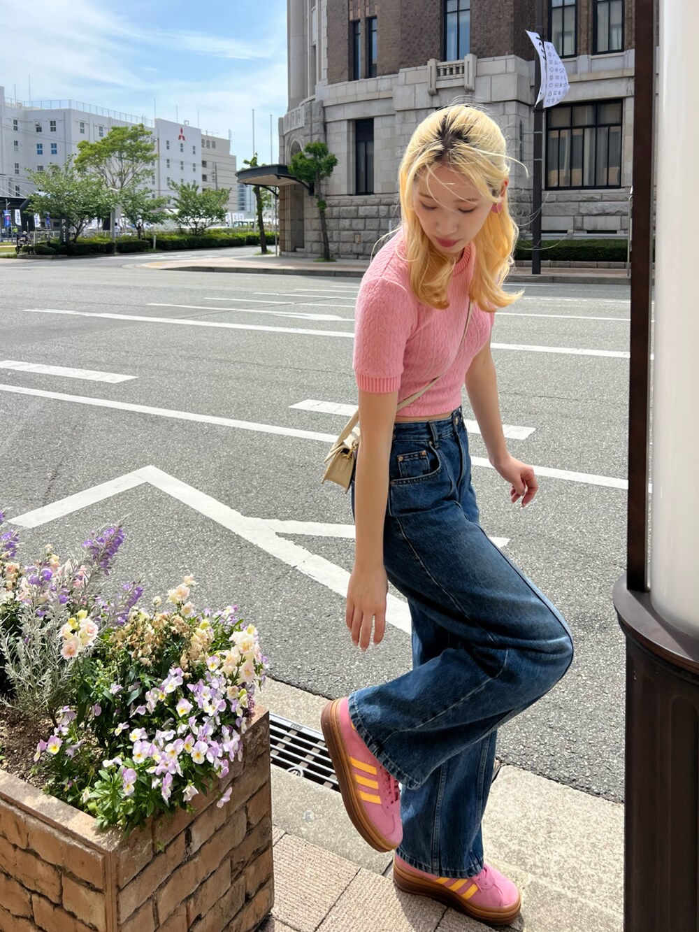 ピンク系のスニーカー、ブルー系のデニムパンツ、ピンク系のトップスを着用したレディースの春コーディネートの3枚目の写真