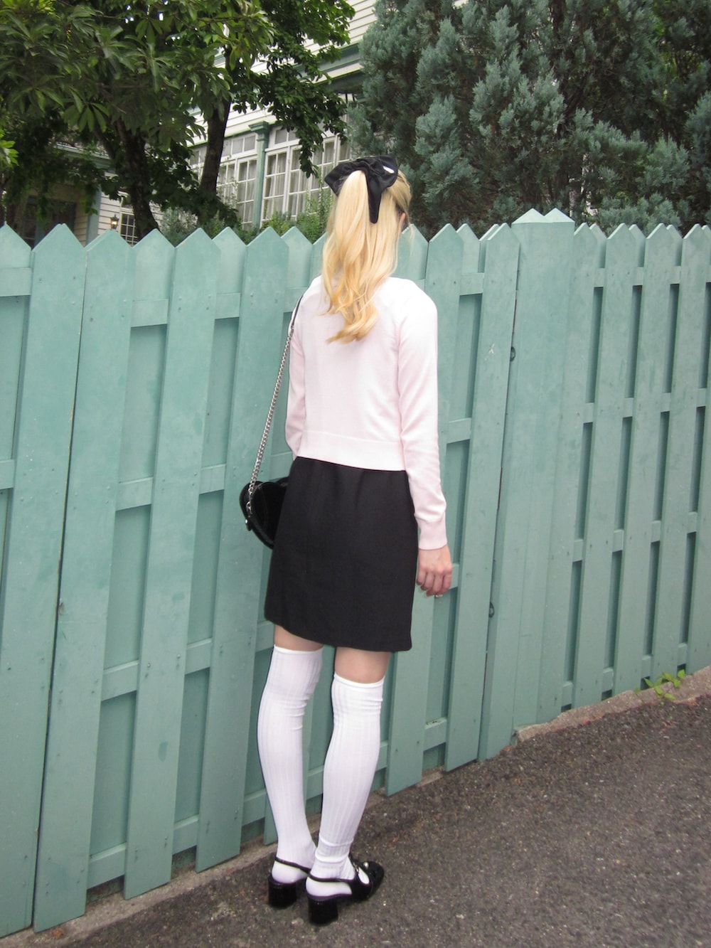 ブラック系のワンピース、ピンク系のカーディガン/ボレロ、ブラック系のショルダーバッグを着用したレディースの夏コーディネートの2枚目の写真