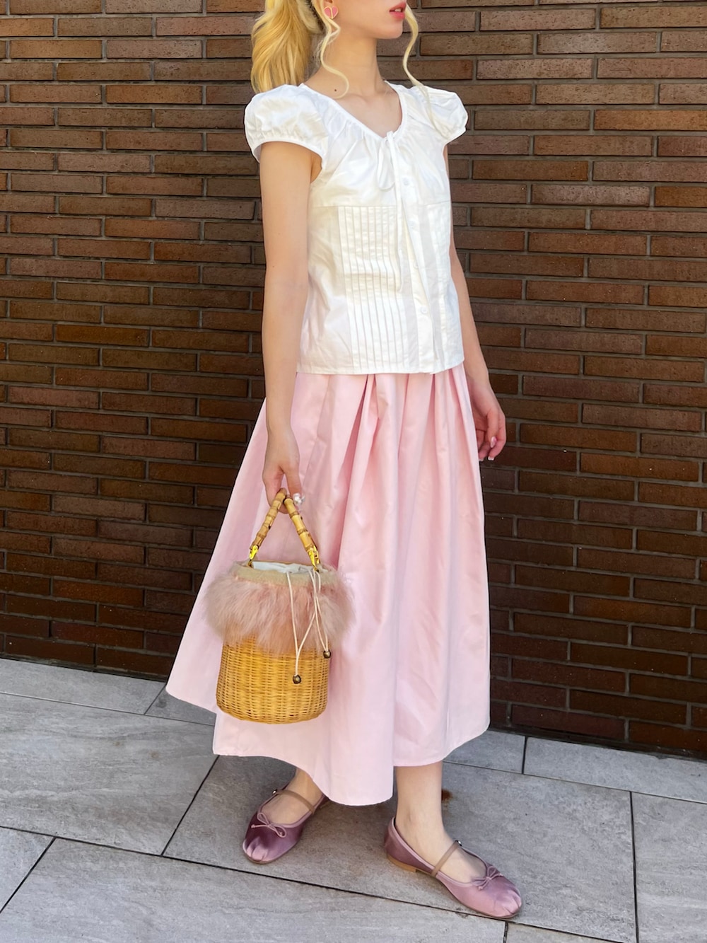 ピンク系のバレエシューズ、ピンク系のスカート、その他のかごバッグを着用したレディースの夏コーディネートの2枚目の写真