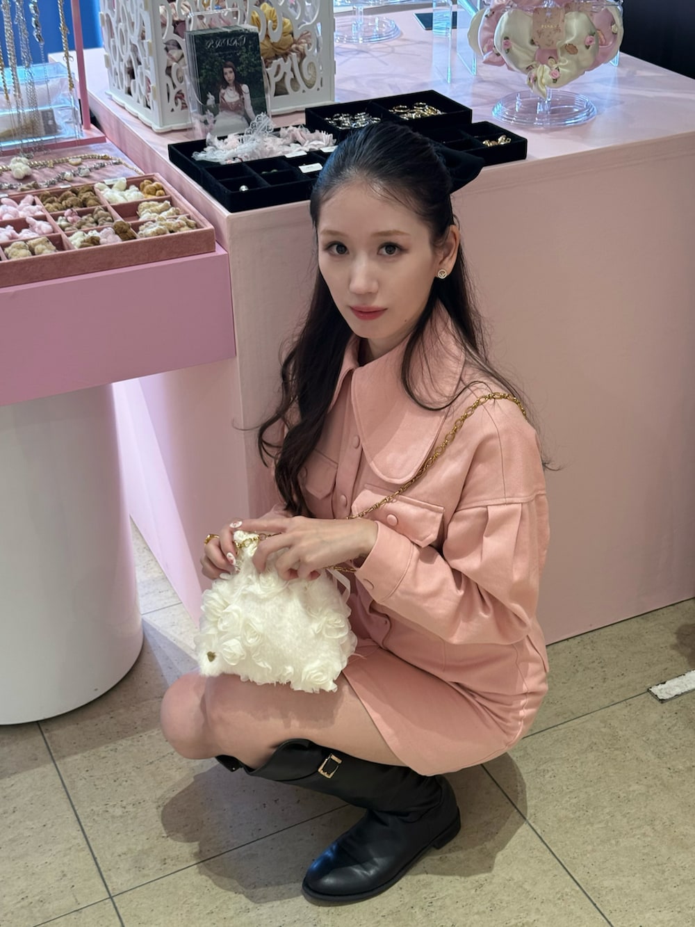 ピンク系のワンピース/ドレス、ブラック系のブーツ、ブラック系のシュシュを着用したレディースの秋コーディネートの2枚目の写真