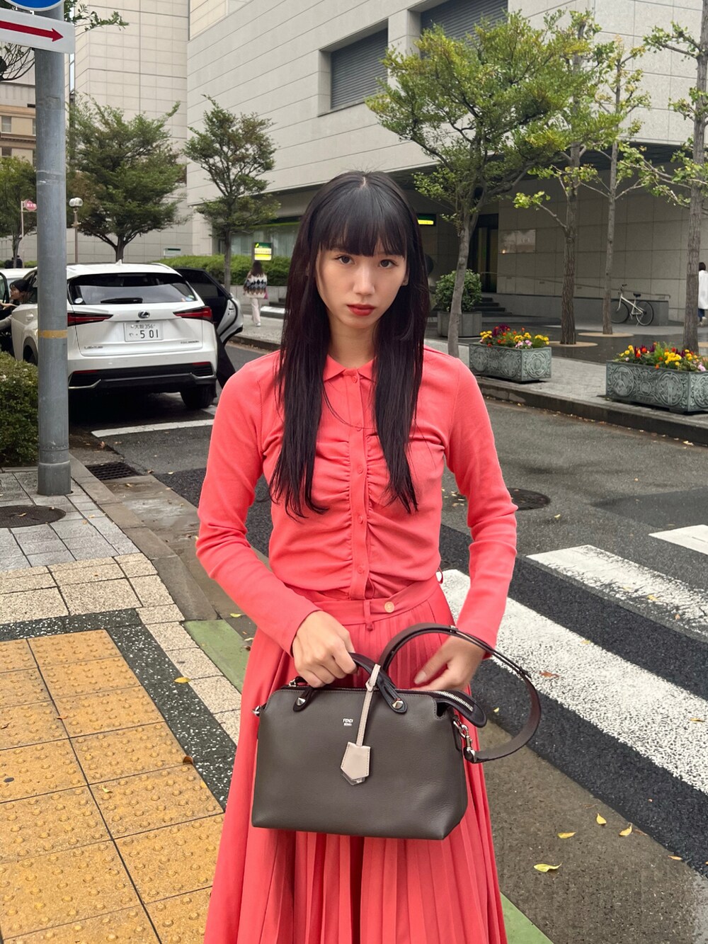 ピンク系のスカート、ピンク系のトップス、ブラック系のブーツを着用したレディースの春コーディネートの2枚目の写真
