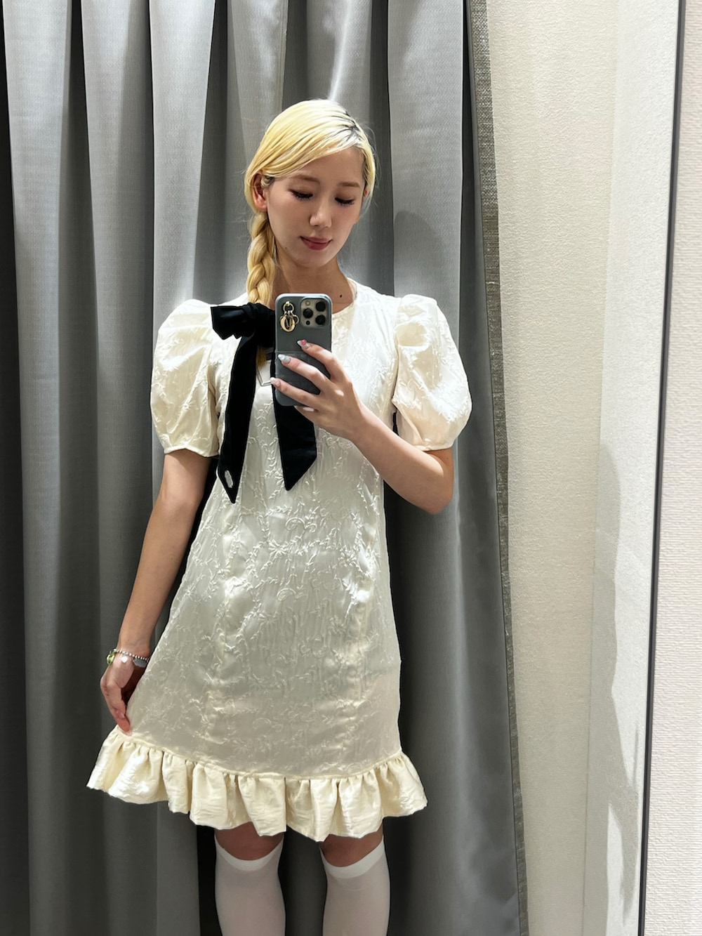 ブラック系のパンプス、ホワイト系のドレス、ブラック系のシュシュを着用したレディースの夏コーディネートの2枚目の写真