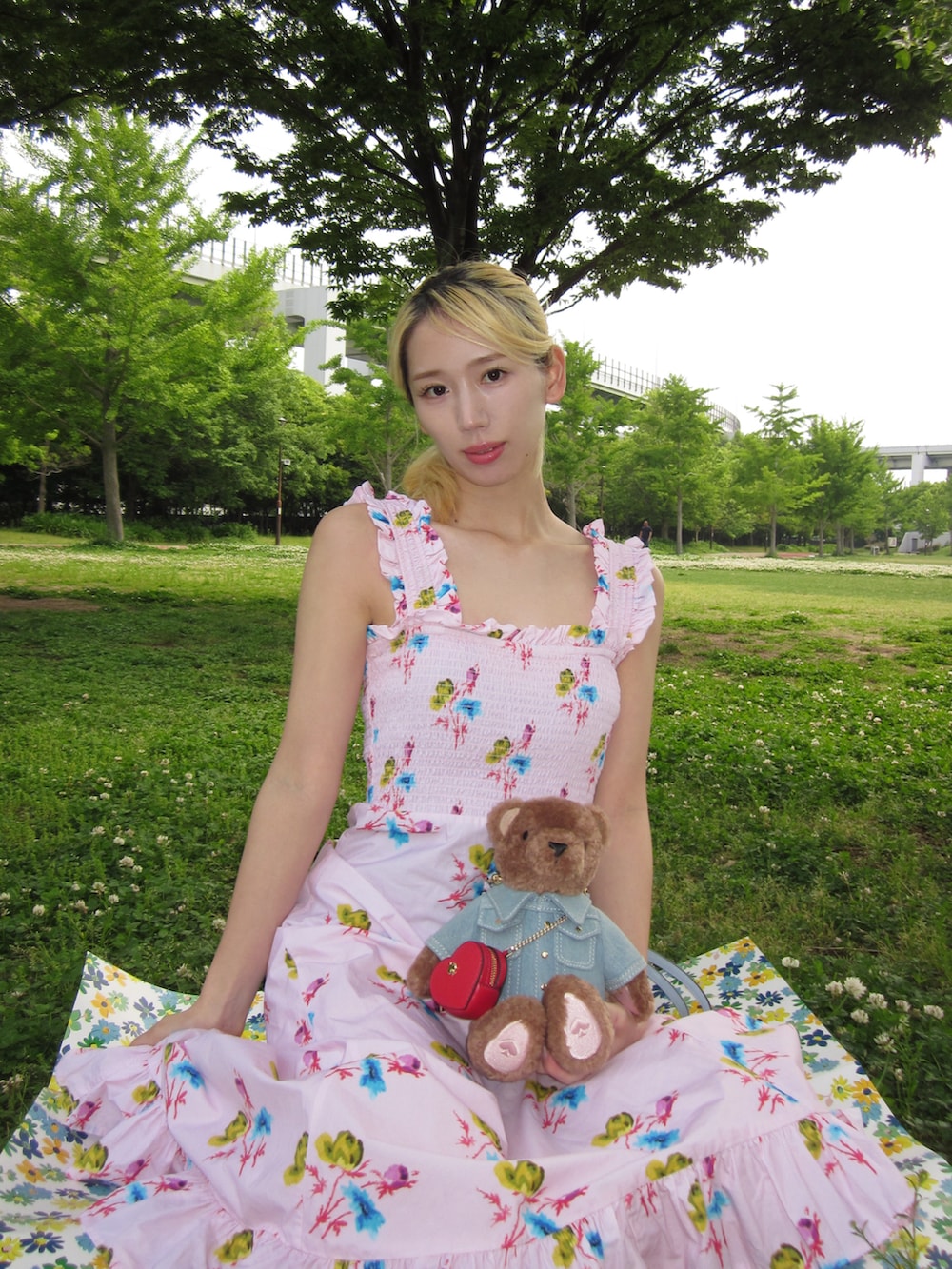 ピンク系のワンピース、ブラウン系のショルダーバッグ、ピンク系のヘアピンを着用したレディースの春コーディネートの2枚目の写真