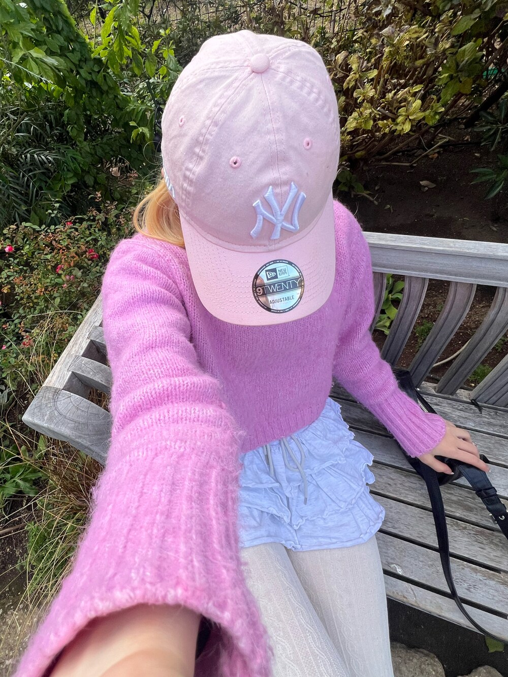 ピンク系のニット/セーター、グレー系のスカート、ベージュ系のブーツを着用したレディースの冬コーディネートの2枚目の写真