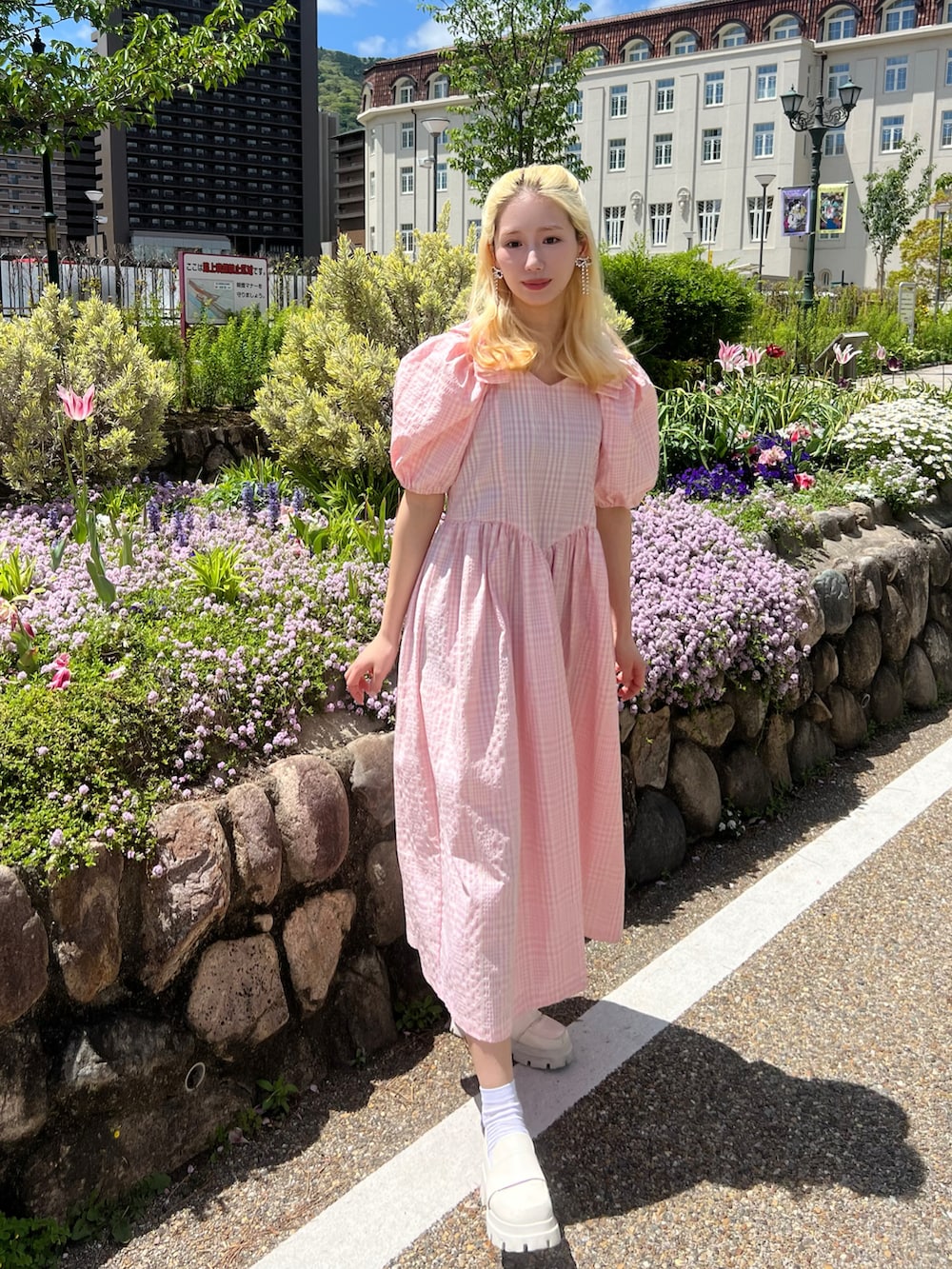 ピンク系のワンピース、ホワイト系のローファー、シルバー系のイヤリングを着用したレディースの春コーディネートの2枚目の写真