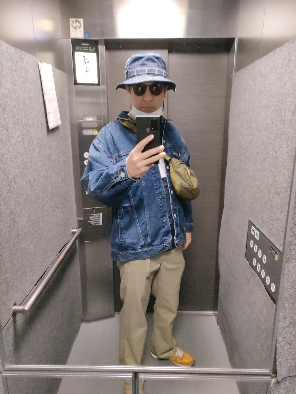 オレンジ系のスニーカー、ベージュ系のパンツ、ブルー系のデニムジャケットを着用したメンズの春コーディネートの3枚目の写真