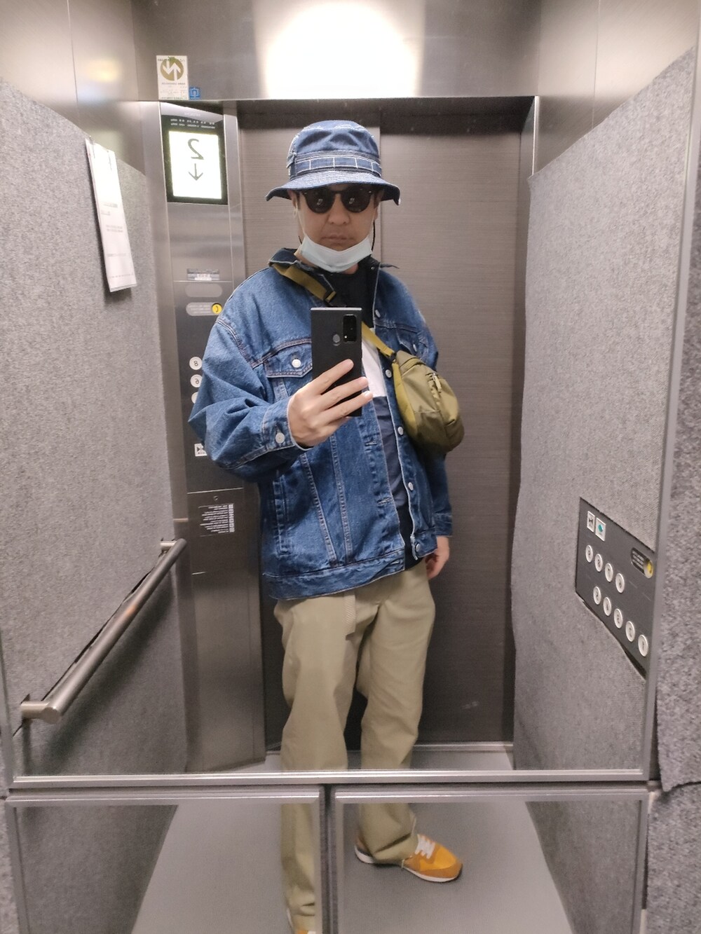 オレンジ系のスニーカー、ベージュ系のパンツ、ブルー系のデニムジャケットを着用したメンズの春コーディネートの4枚目の写真