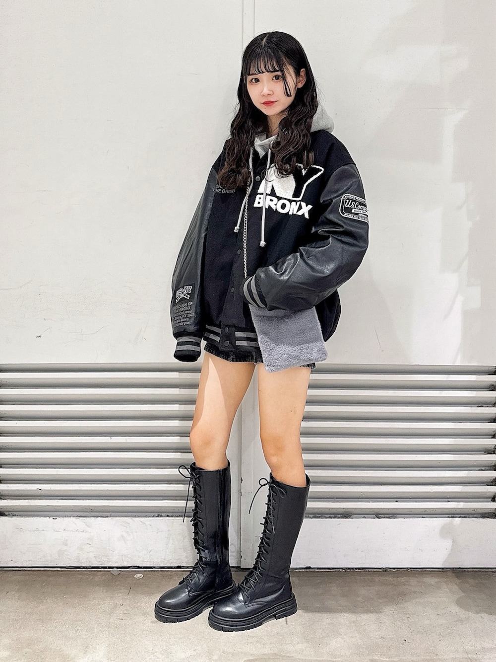 ブラック系のブーツ、グレー系のショルダーバッグ、ブラック系のスタジャンを着用したレディースの冬コーディネートの2枚目の写真