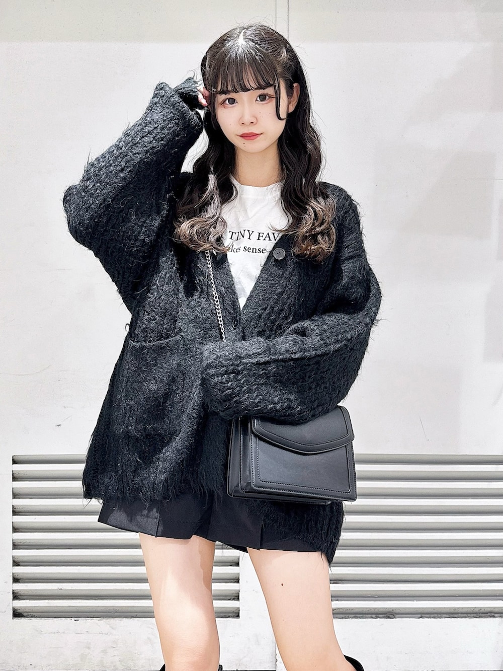 ブラック系のブーツ、ブラック系のカーディガン/ボレロ、ホワイト系のTシャツ/カットソーを着用したレディースの冬コーディネートの3枚目の写真