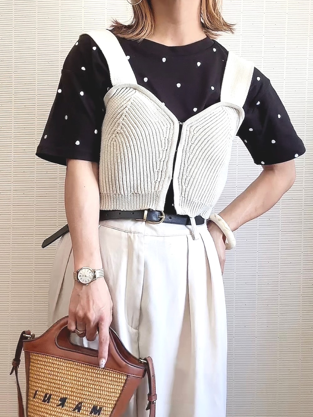ブラック系のTシャツ/カットソー、ホワイト系のニット/セーター、ベージュ系のショルダーバッグを着用したレディースの夏コーディネートの2枚目の写真