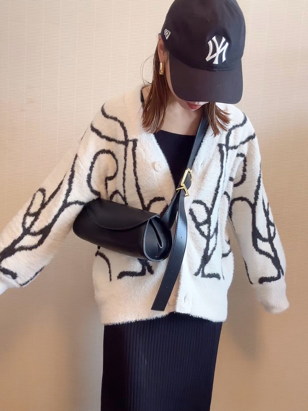 ホワイト系のカーディガン/ボレロ、ブラウン系のショルダーバッグ、ブラック系のスカートを着用したレディースの秋コーディネートの3枚目の写真