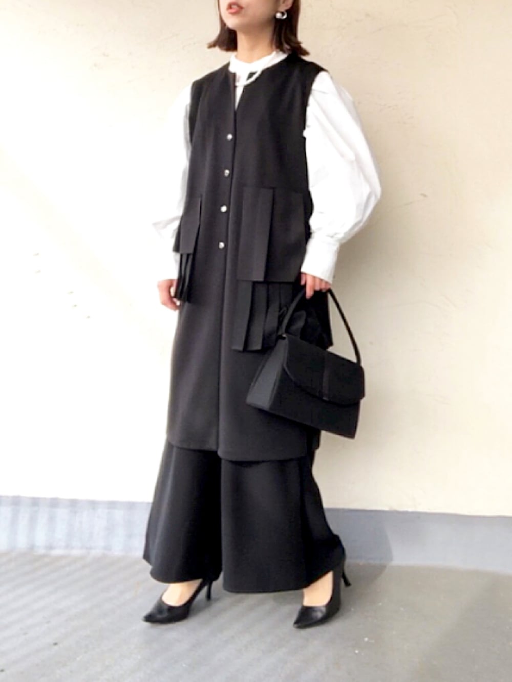 ブラック系のその他アウター、ホワイト系のシャツ/ブラウスを着用したレディースの春コーディネートの2枚目の写真