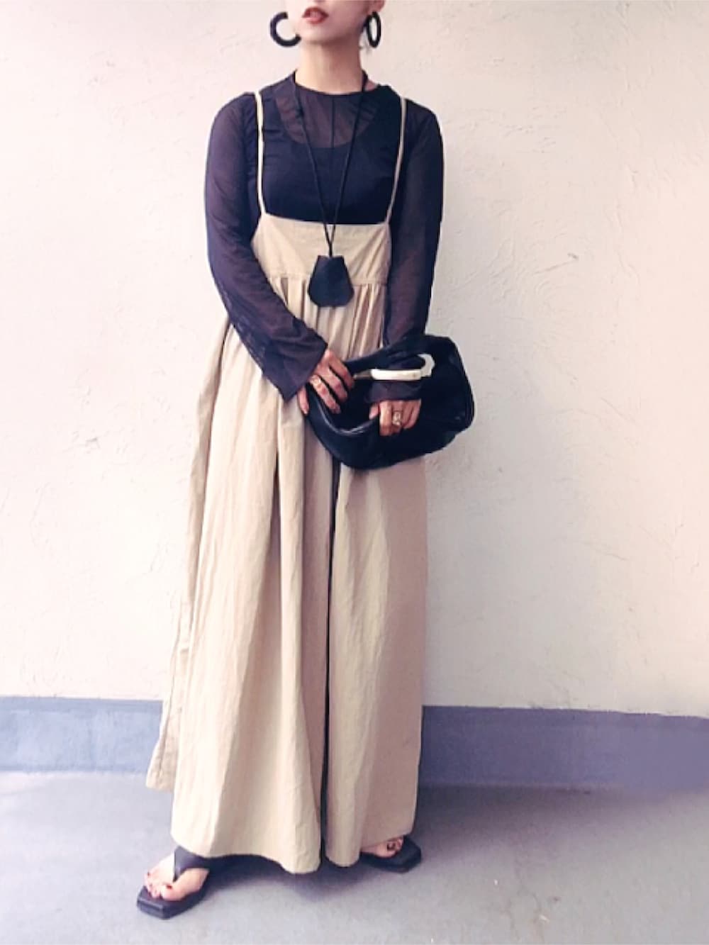 ブラック系のTシャツ/カットソー、ブラック系のハンドバッグ、ベージュ系のワンピースを着用したレディースの夏コーディネートの2枚目の写真