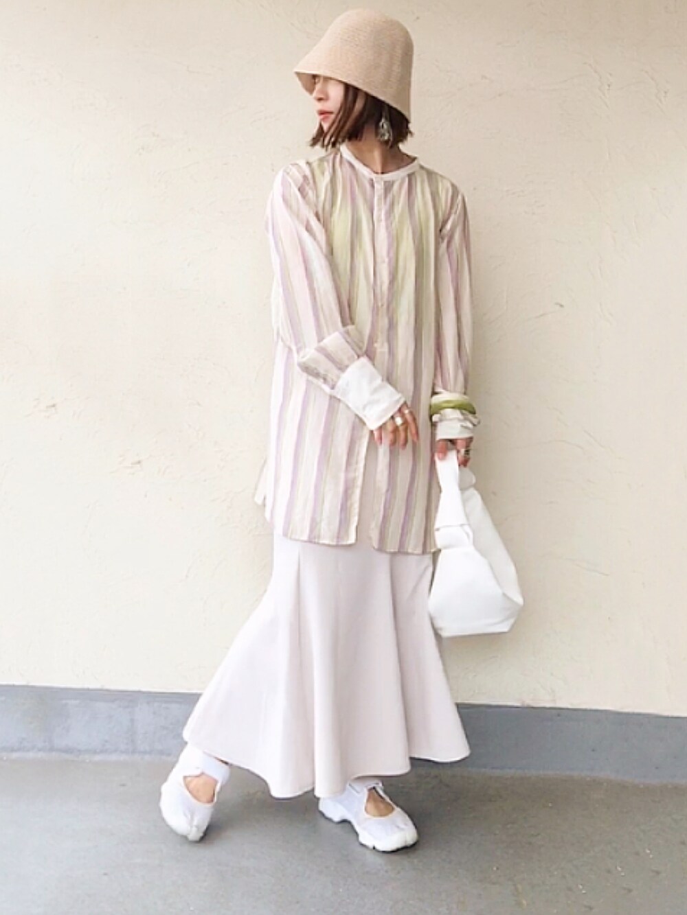 ホワイト系のシャツ/ブラウス、ホワイト系のハンドバッグ、ブラック系のスカートを着用したレディースの夏コーディネートの3枚目の写真