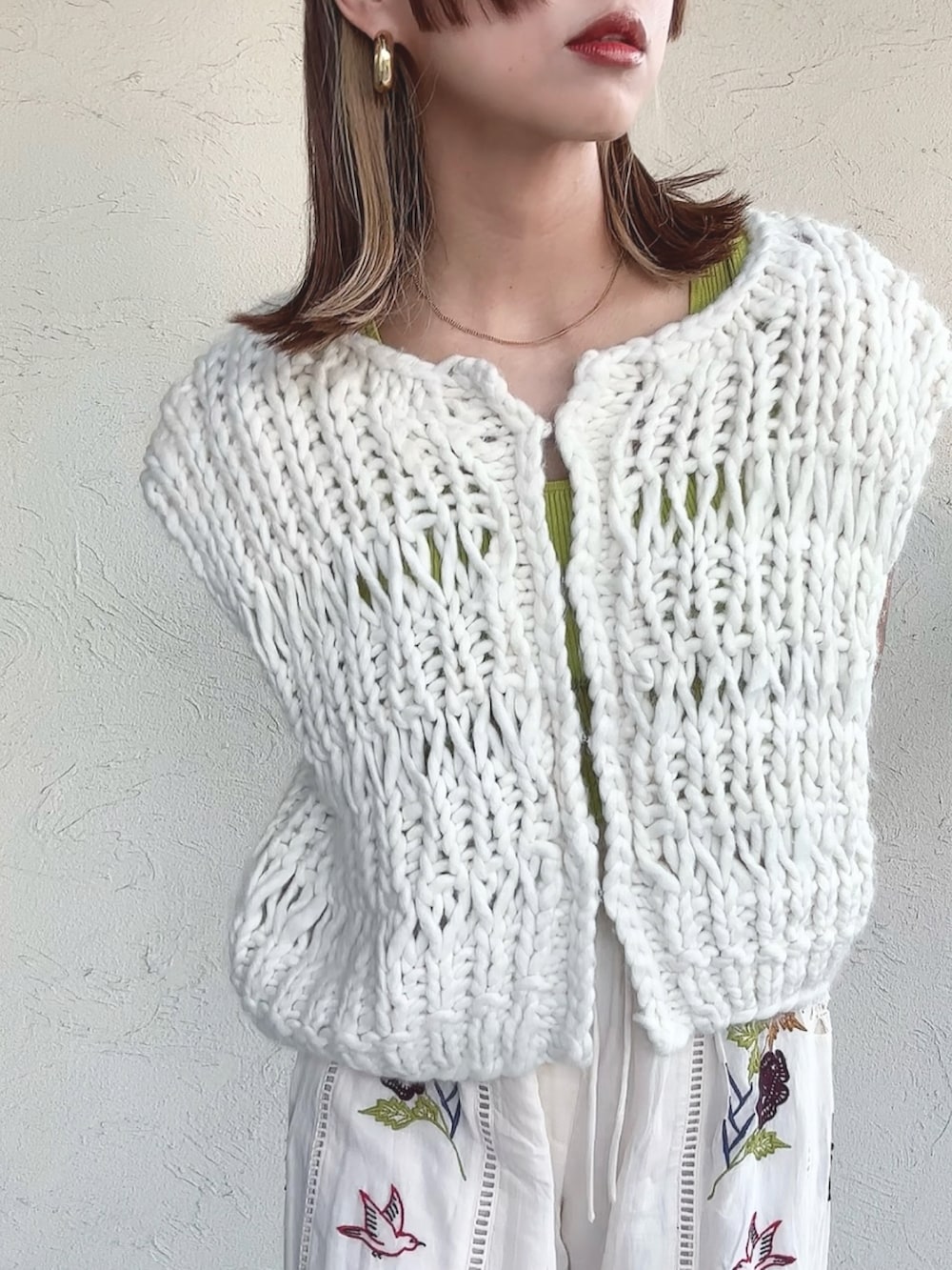 ホワイト系のベスト、ホワイト系のその他パンツ、ブラック系のサンダルを着用したレディースの秋コーディネートの3枚目の写真