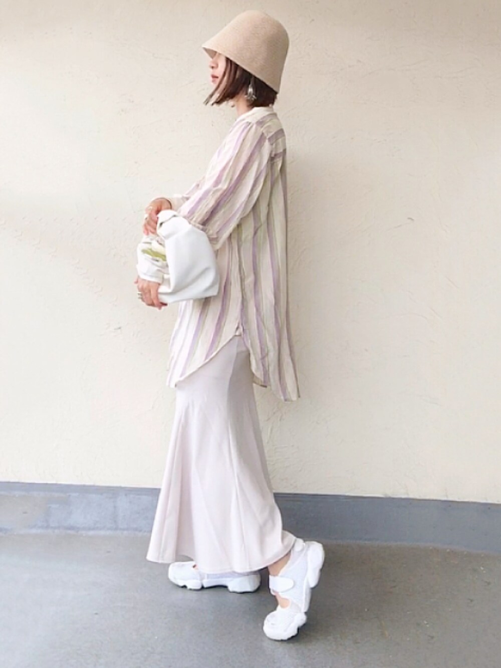 ホワイト系のシャツ/ブラウス、ホワイト系のハンドバッグ、ブラック系のスカートを着用したレディースの夏コーディネートの2枚目の写真