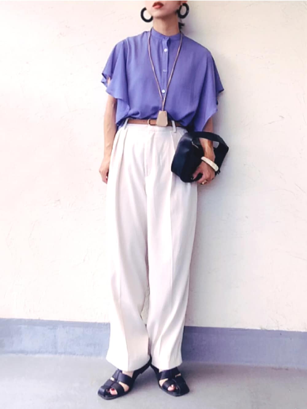 ブルー系のシャツ/ブラウス、ブラック系のハンドバッグ、ホワイト系のスラックスを着用したレディースの夏コーディネートの2枚目の写真