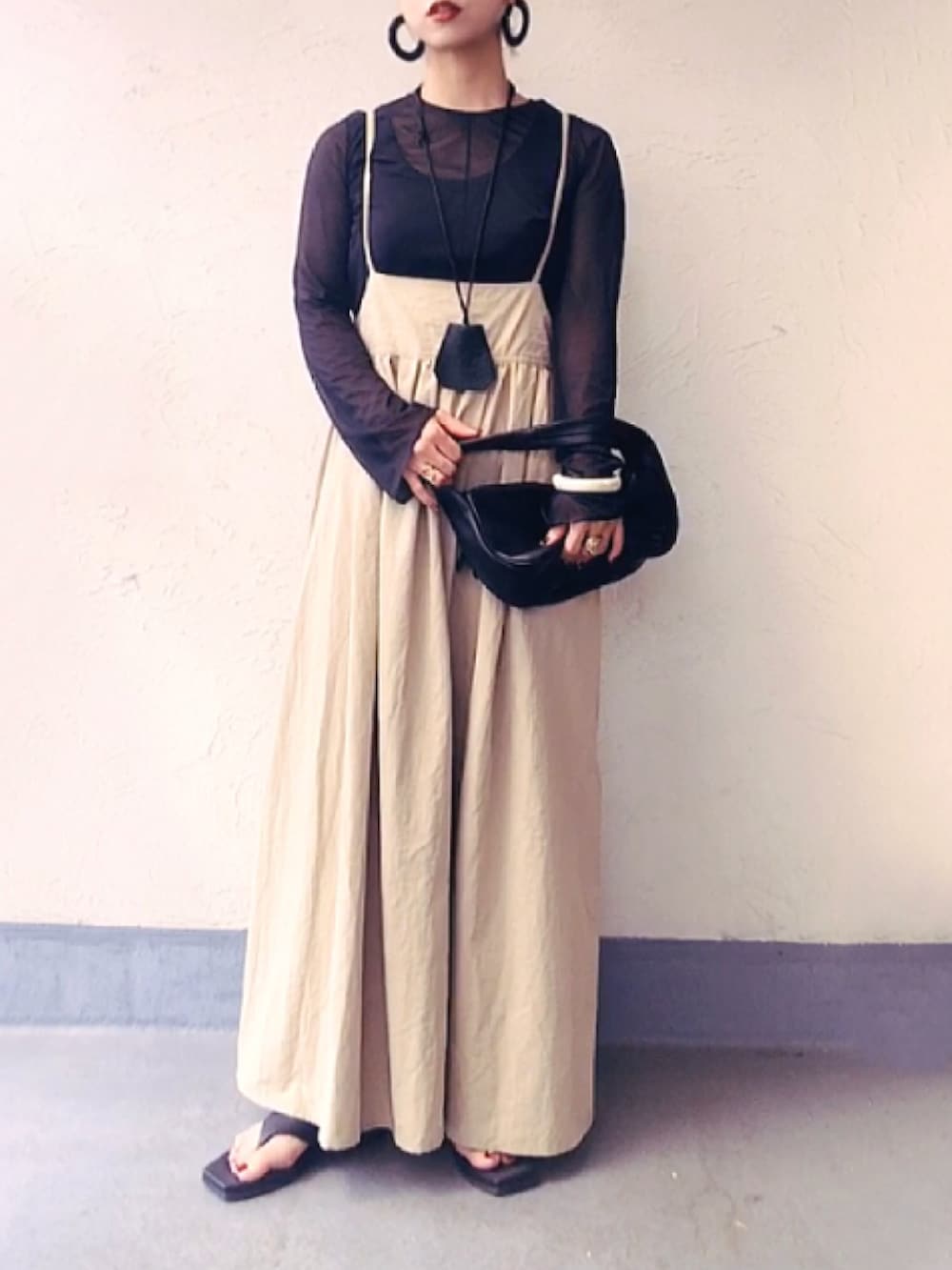 ブラック系のTシャツ/カットソー、ブラック系のハンドバッグ、ベージュ系のワンピースを着用したレディースの夏コーディネートの3枚目の写真