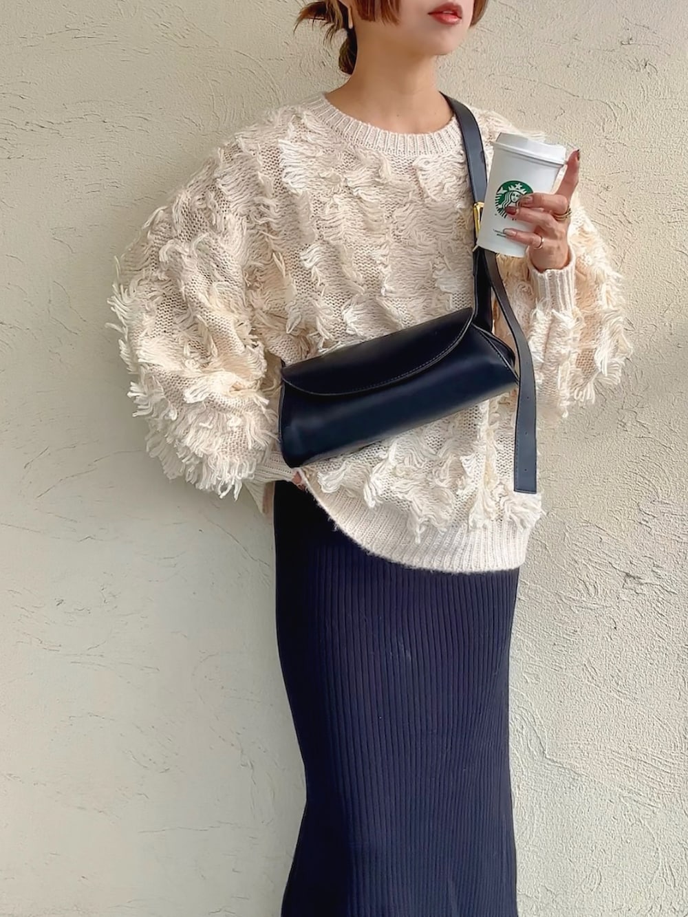 ホワイト系のニット/セーター、ブラウン系のショルダーバッグ、ブラック系のスカートを着用したレディースの秋コーディネートの3枚目の写真