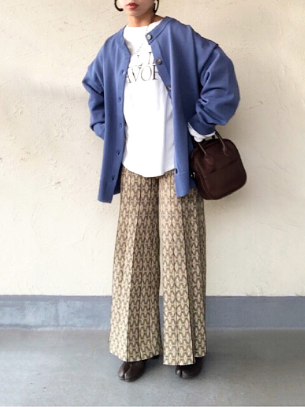 ホワイト系のTシャツ/カットソー、ブルー系のカーディガン/ボレロ、ブラウン系のボストンバッグを着用したレディースの冬コーディネートの2枚目の写真
