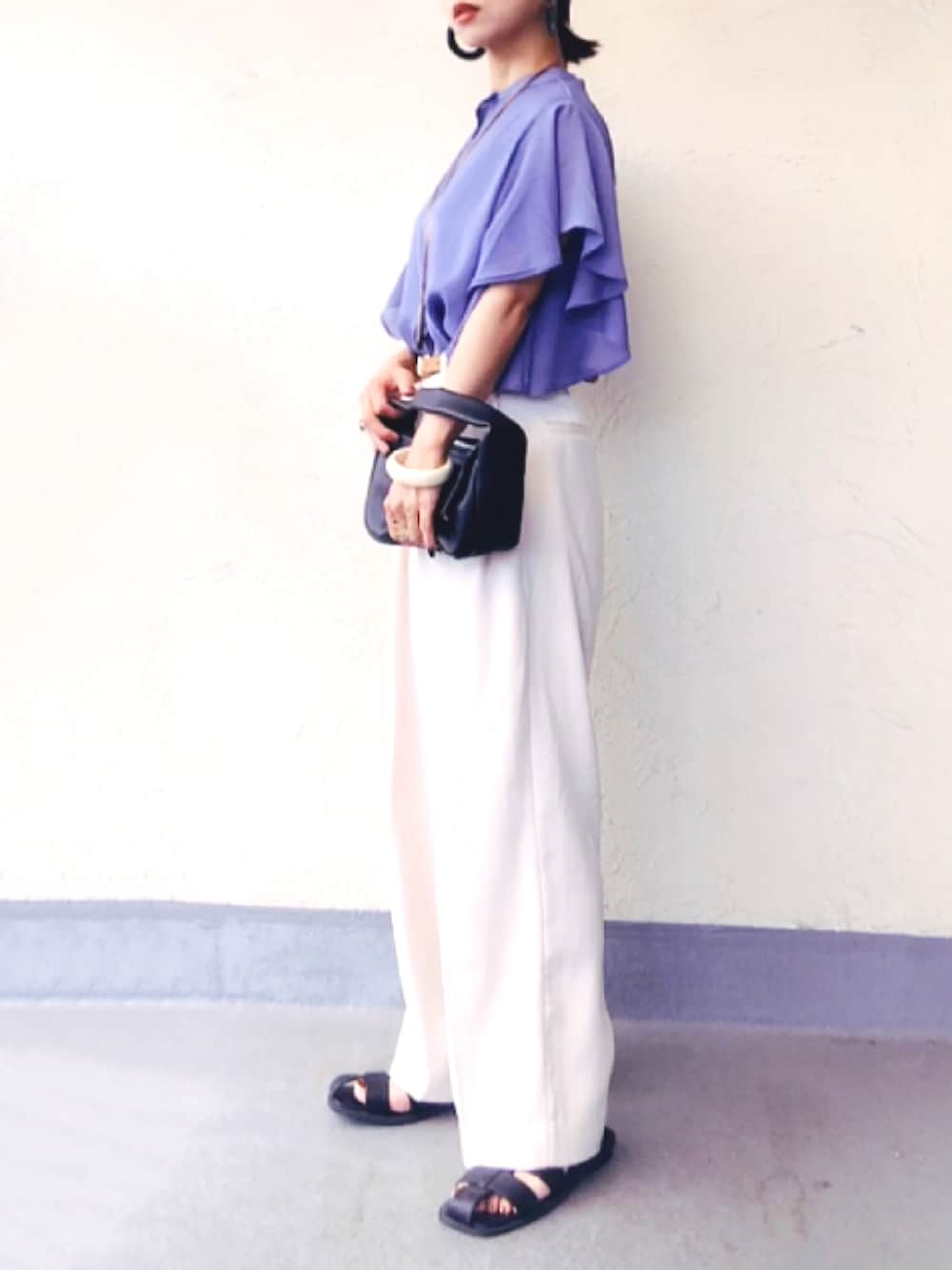 ブルー系のシャツ/ブラウス、ブラック系のハンドバッグ、ホワイト系のスラックスを着用したレディースの夏コーディネートの3枚目の写真