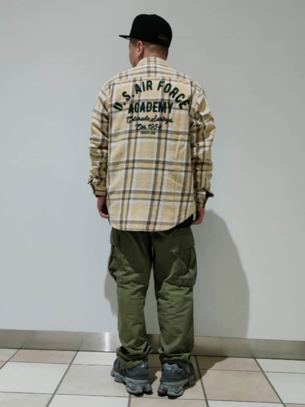 ベージュ系のシャツ/ブラウス、ブラック系のTシャツ/カットソー、グリーン系のカーゴパンツを着用したメンズの冬コーディネートの2枚目の写真