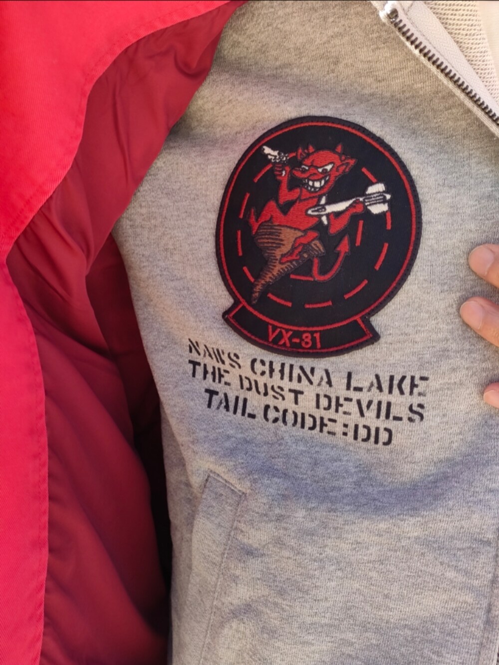 ピンク系のブルゾン、グレー系のパーカー、ブルー系のデニムパンツを着用したメンズの冬コーディネートの5枚目の写真