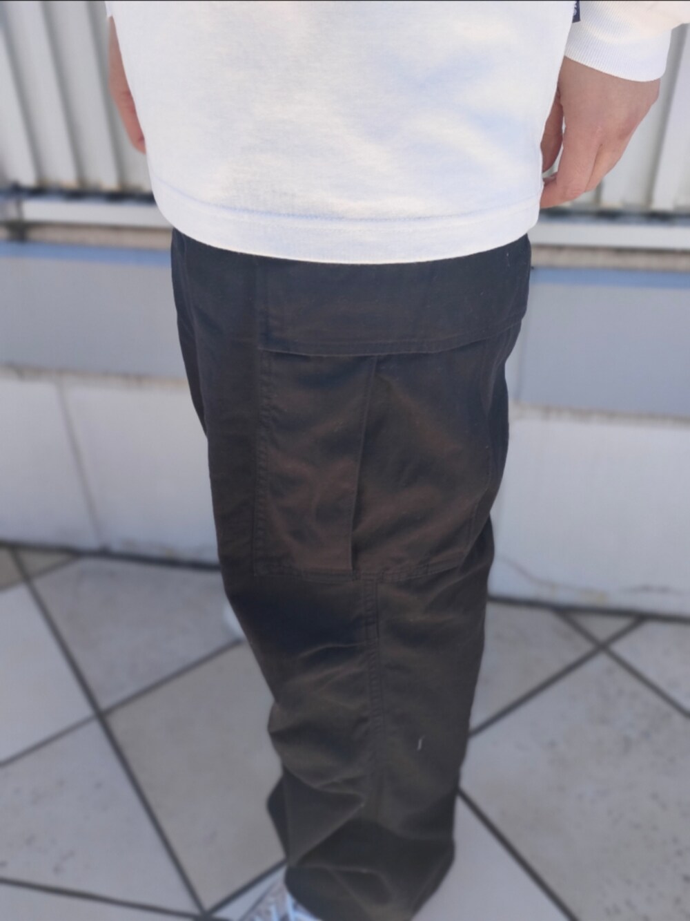 ホワイト系のTシャツ/カットソー、ブラック系のカーゴパンツ、ホワイト系のキャップを着用したメンズの冬コーディネートの5枚目の写真