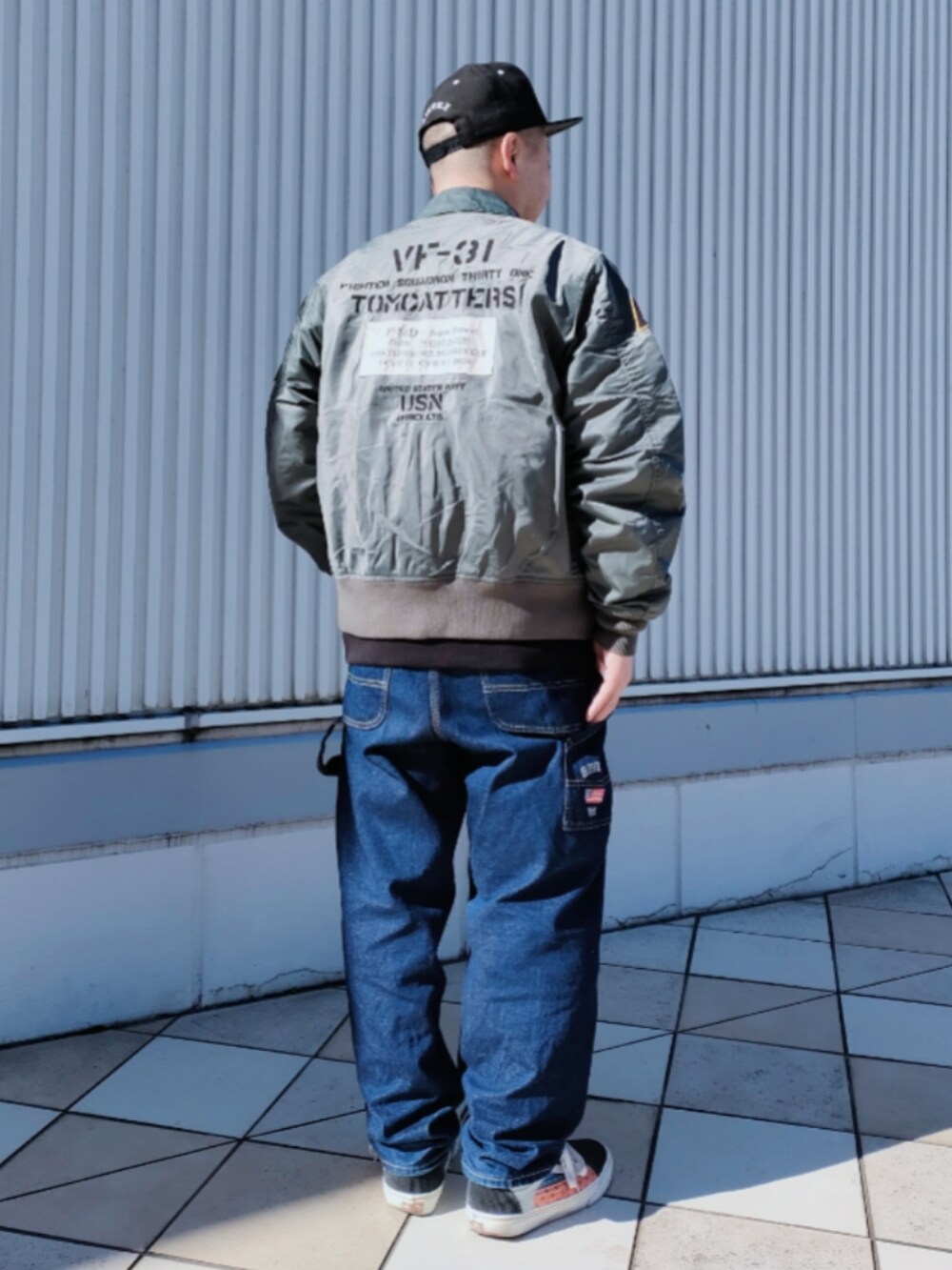 グリーン系のMA-1、ブラック系のスウェット、ブルー系のデニムパンツを着用したメンズの冬コーディネートの2枚目の写真