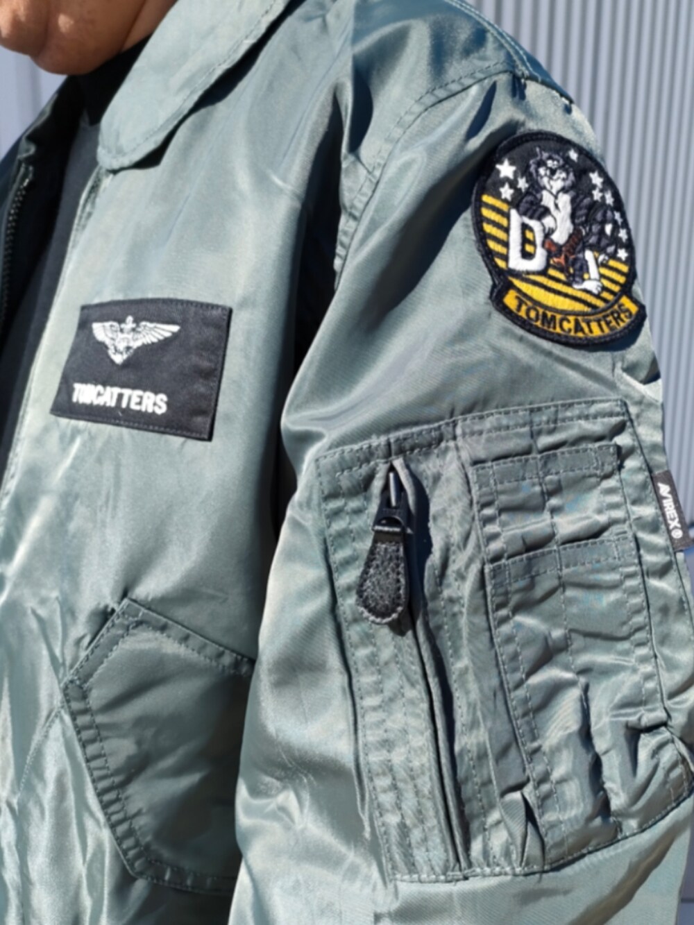 グリーン系のMA-1、ブラック系のスウェット、ブルー系のデニムパンツを着用したメンズの冬コーディネートの4枚目の写真