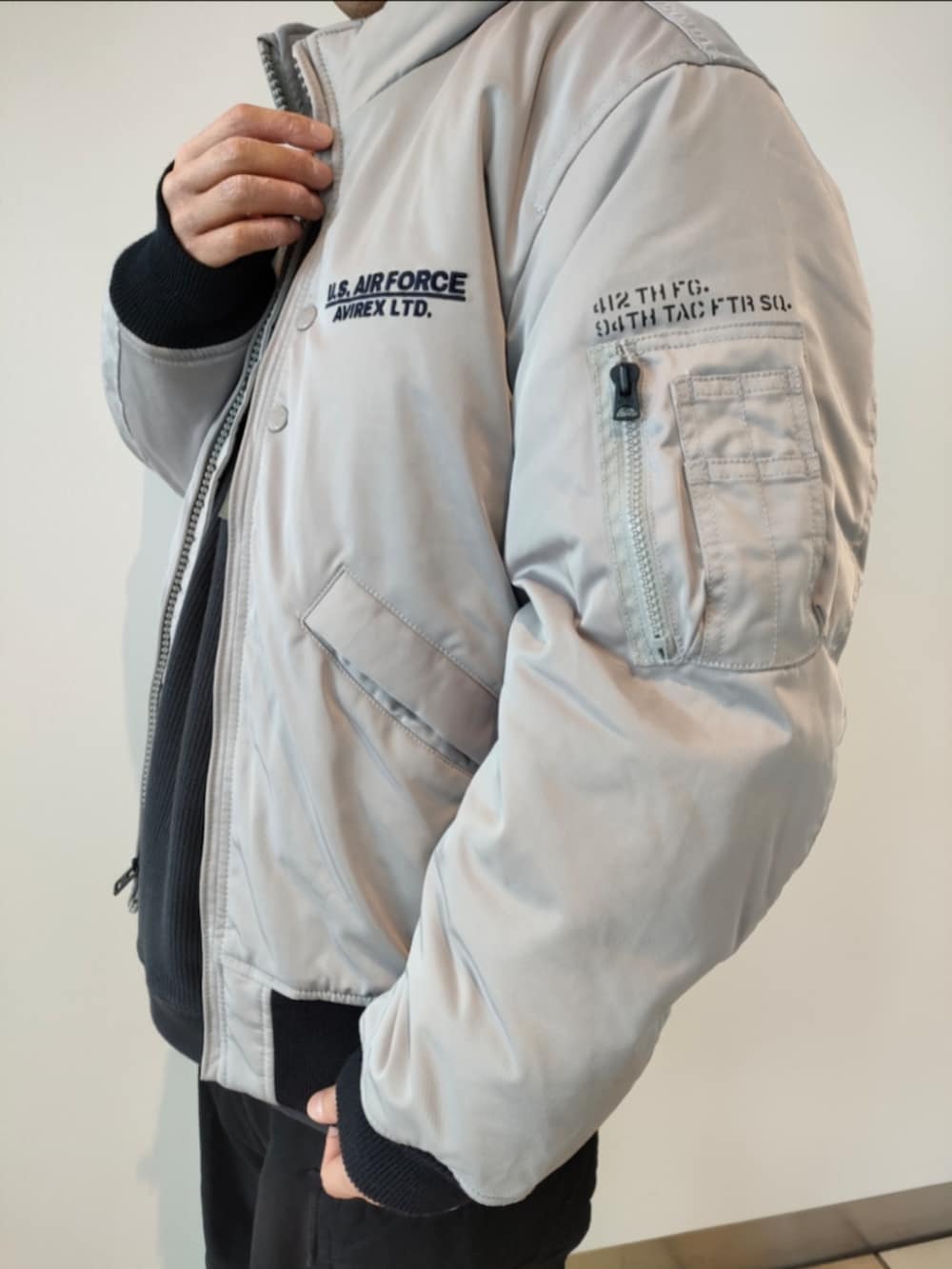 グレー系のMA-1、グレー系のTシャツ/カットソー、ブラック系のカーゴパンツを着用したメンズの冬コーディネートの3枚目の写真