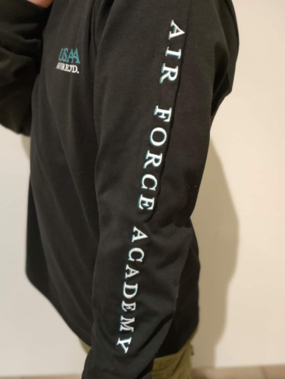 ブラック系のTシャツ/カットソー、グリーン系のカーゴパンツ、ブラック系のキャップを着用したメンズの春コーディネートの5枚目の写真