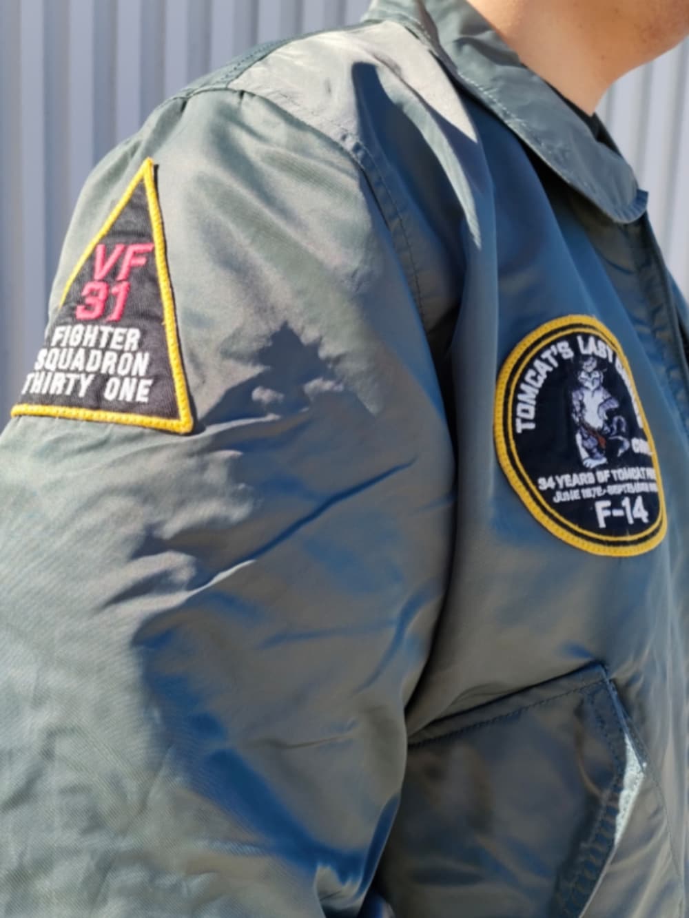 グリーン系のMA-1、ブラック系のスウェット、ブルー系のデニムパンツを着用したメンズの冬コーディネートの5枚目の写真