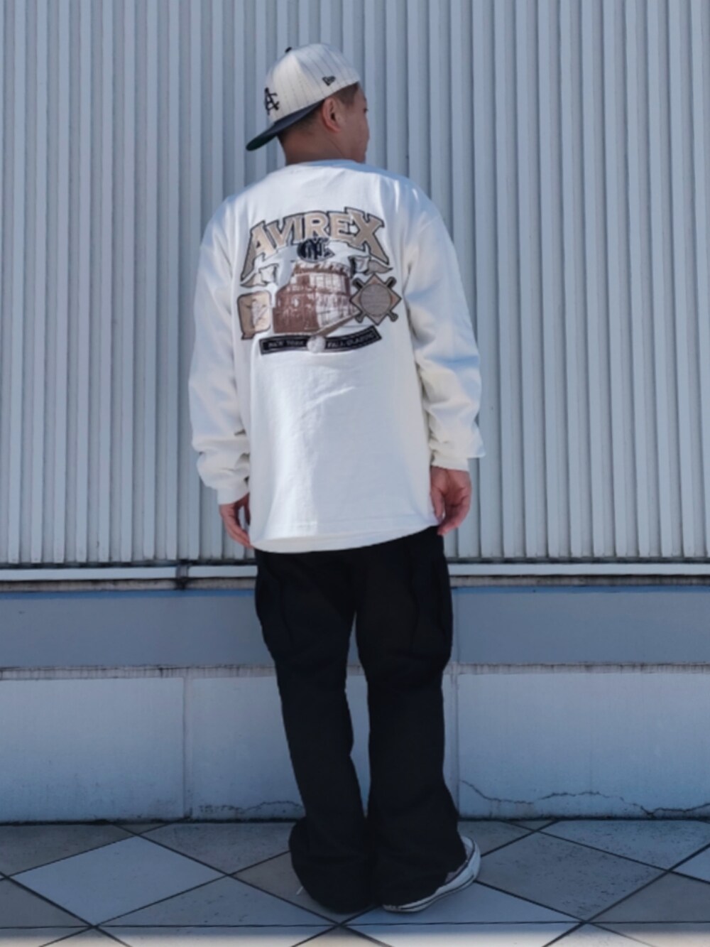 ホワイト系のTシャツ/カットソー、ブラック系のカーゴパンツ、ホワイト系のキャップを着用したメンズの冬コーディネートの2枚目の写真