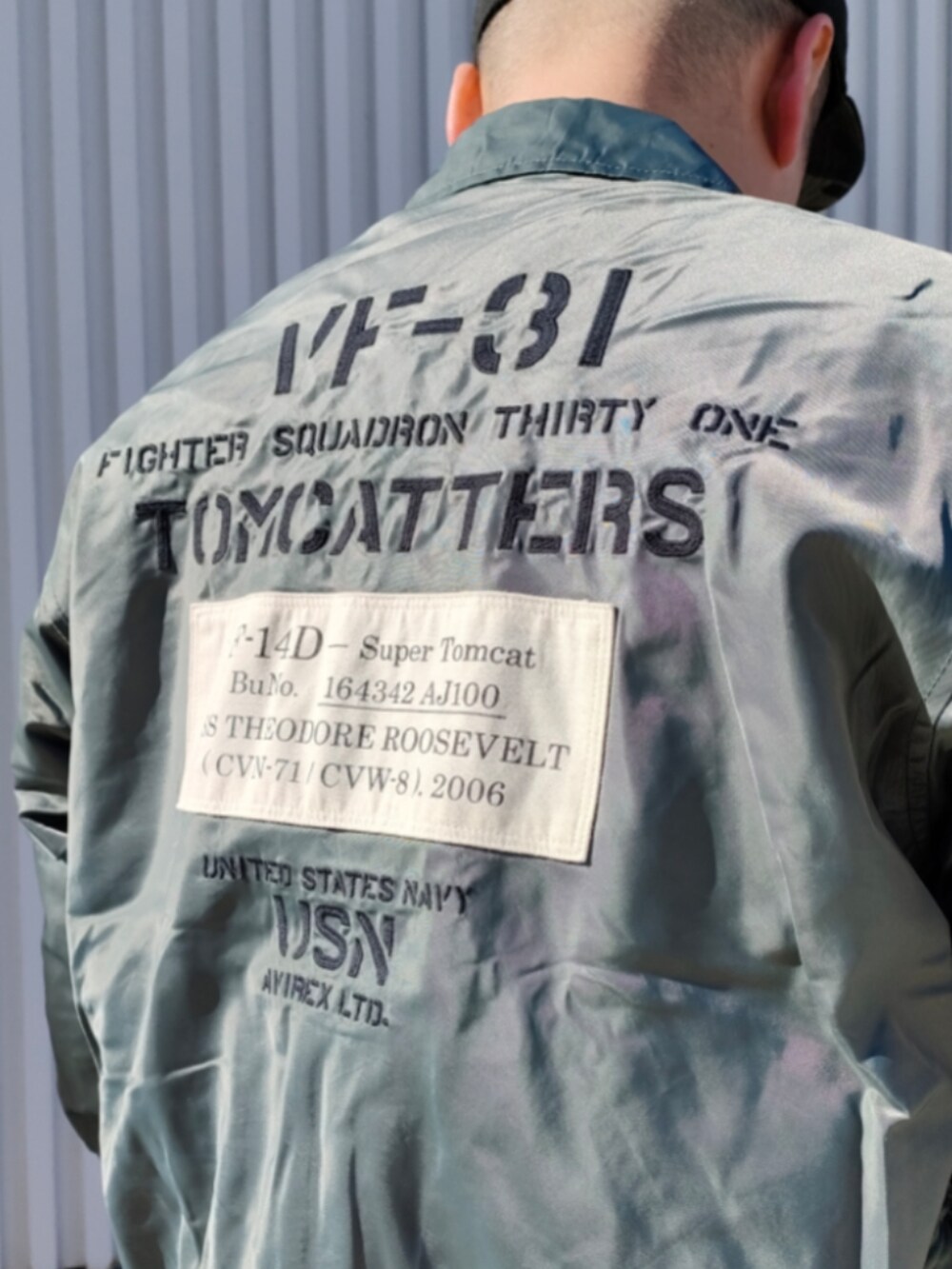 グリーン系のMA-1、ブラック系のスウェット、ブルー系のデニムパンツを着用したメンズの冬コーディネートの3枚目の写真