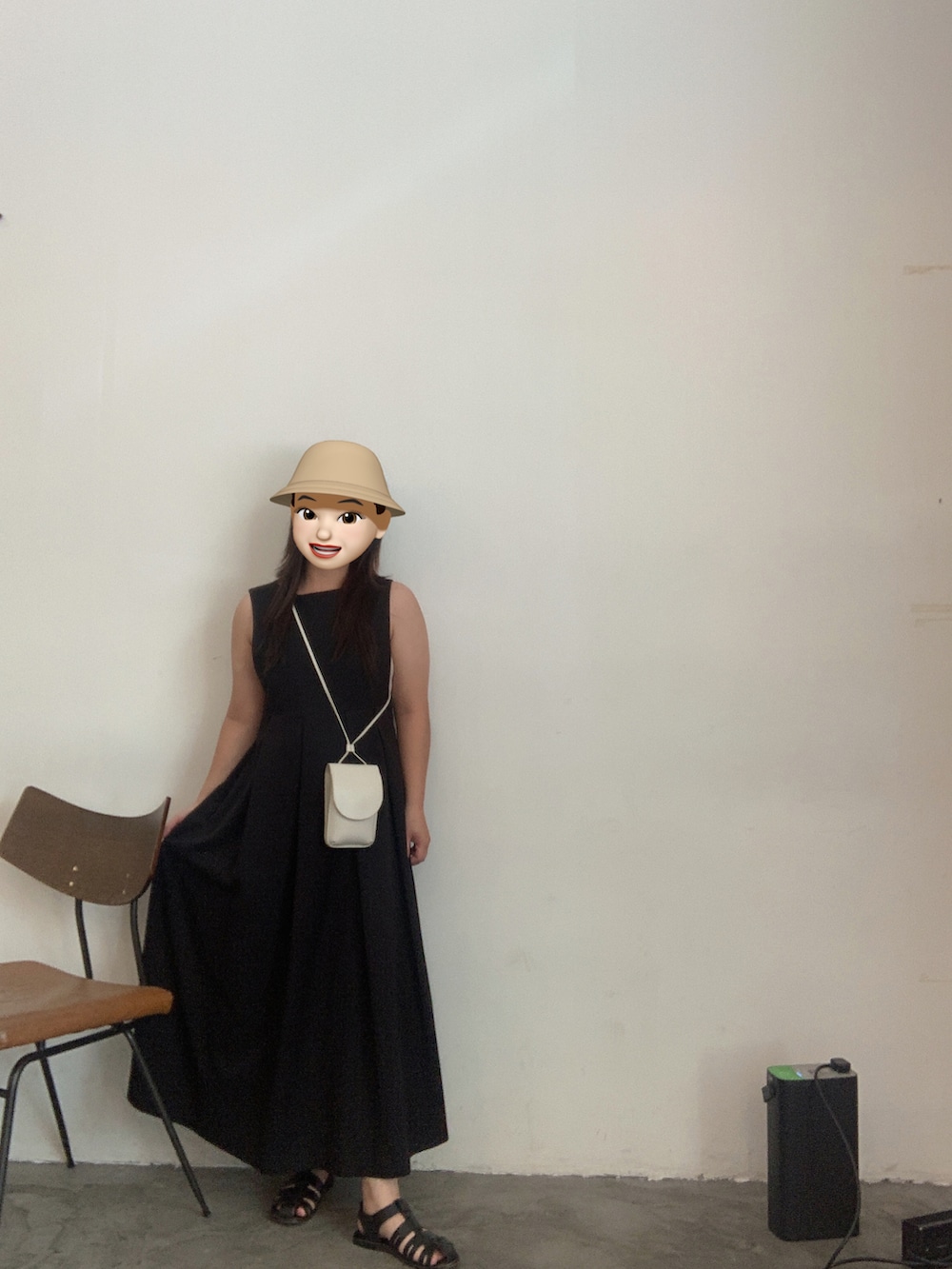 ホワイト系のショルダーバッグ、ブラック系のワンピース、ブラック系のサンダルを着用したレディースの秋コーディネートの2枚目の写真