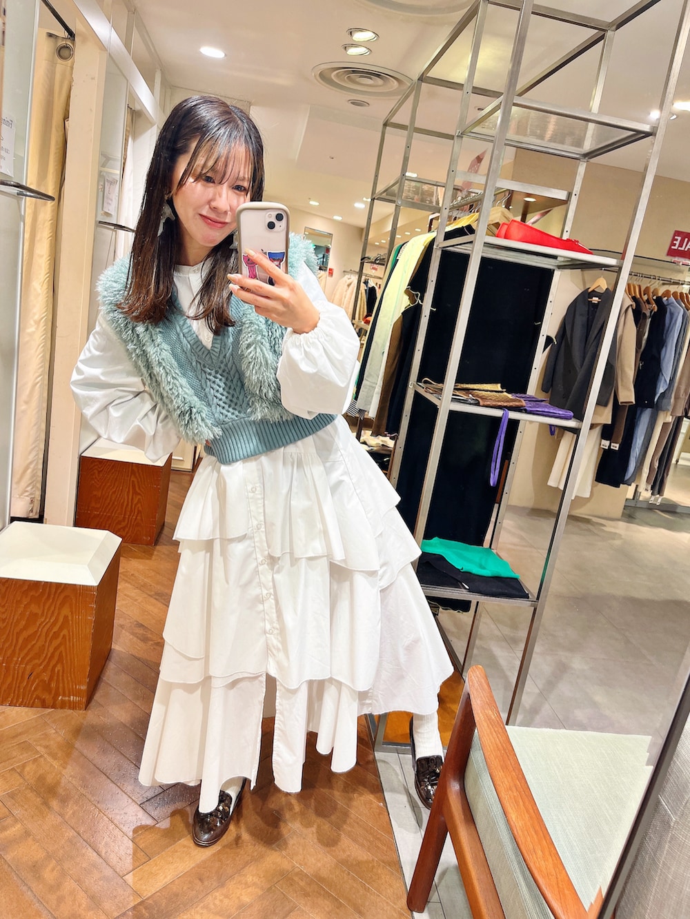 ホワイト系のワンピース、グリーン系のベストを着用したレディースの冬コーディネートの2枚目の写真
