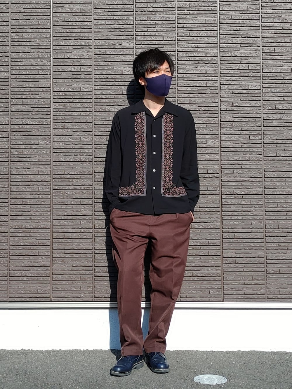 ブルー系のブーツ、ブラウン系のその他パンツ、ブラック系のシャツ/ブラウスを着用したメンズの春コーディネートの2枚目の写真