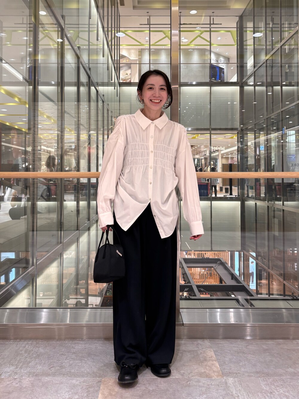 ホワイト系のシャツ/ブラウス、ブラック系のボストンバッグを着用したレディースの冬コーディネートの5枚目の写真