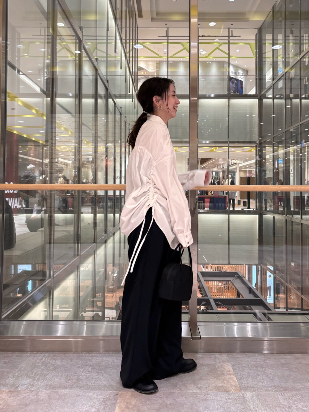 ホワイト系のシャツ/ブラウス、ブラック系のボストンバッグを着用したレディースの冬コーディネートの2枚目の写真