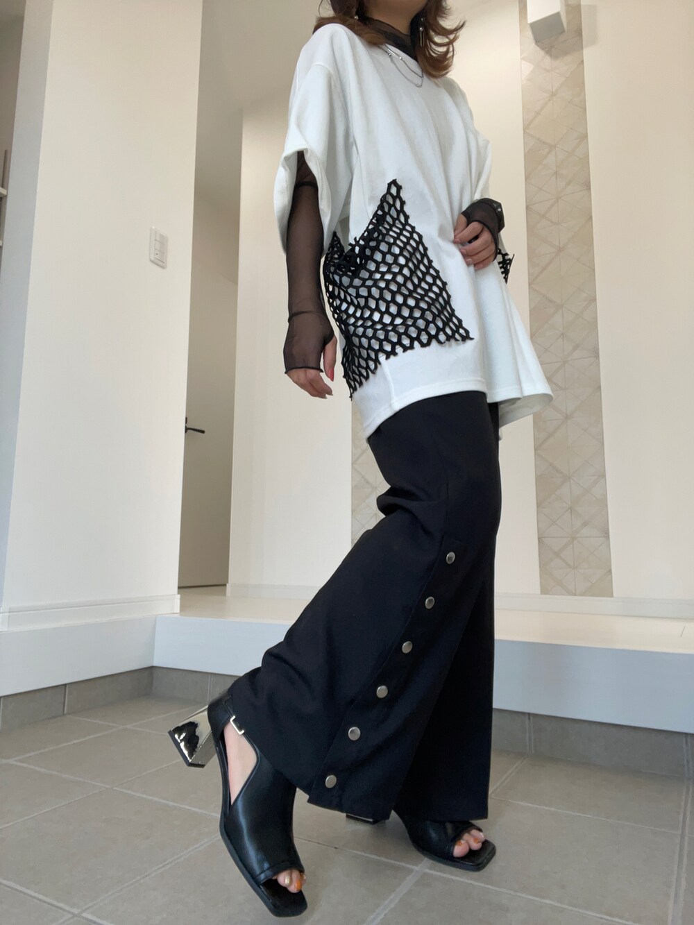 ブラック系のサンダル、ブラック系のスラックス、ホワイト系のTシャツ/カットソーを着用したレディースの春コーディネートの2枚目の写真