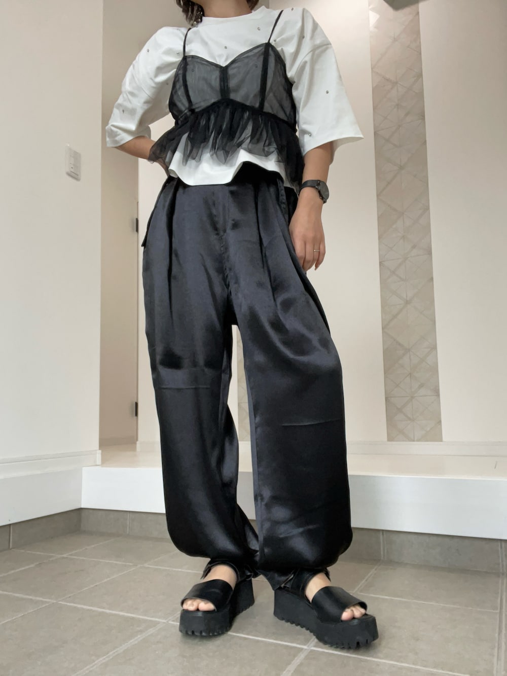 ブラック系のその他パンツ、ブラック系のサンダル、ホワイト系のTシャツ/カットソーを着用したレディースの春コーディネートの3枚目の写真